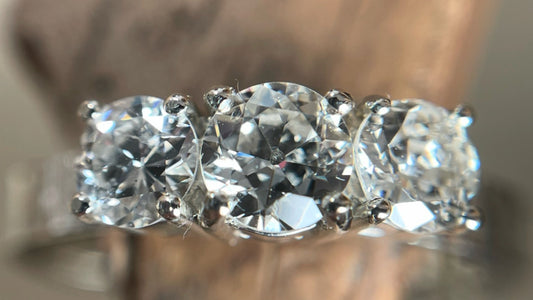 Close up of trilogy diamond ring set with three round cut diamonds in 9ct white gold.