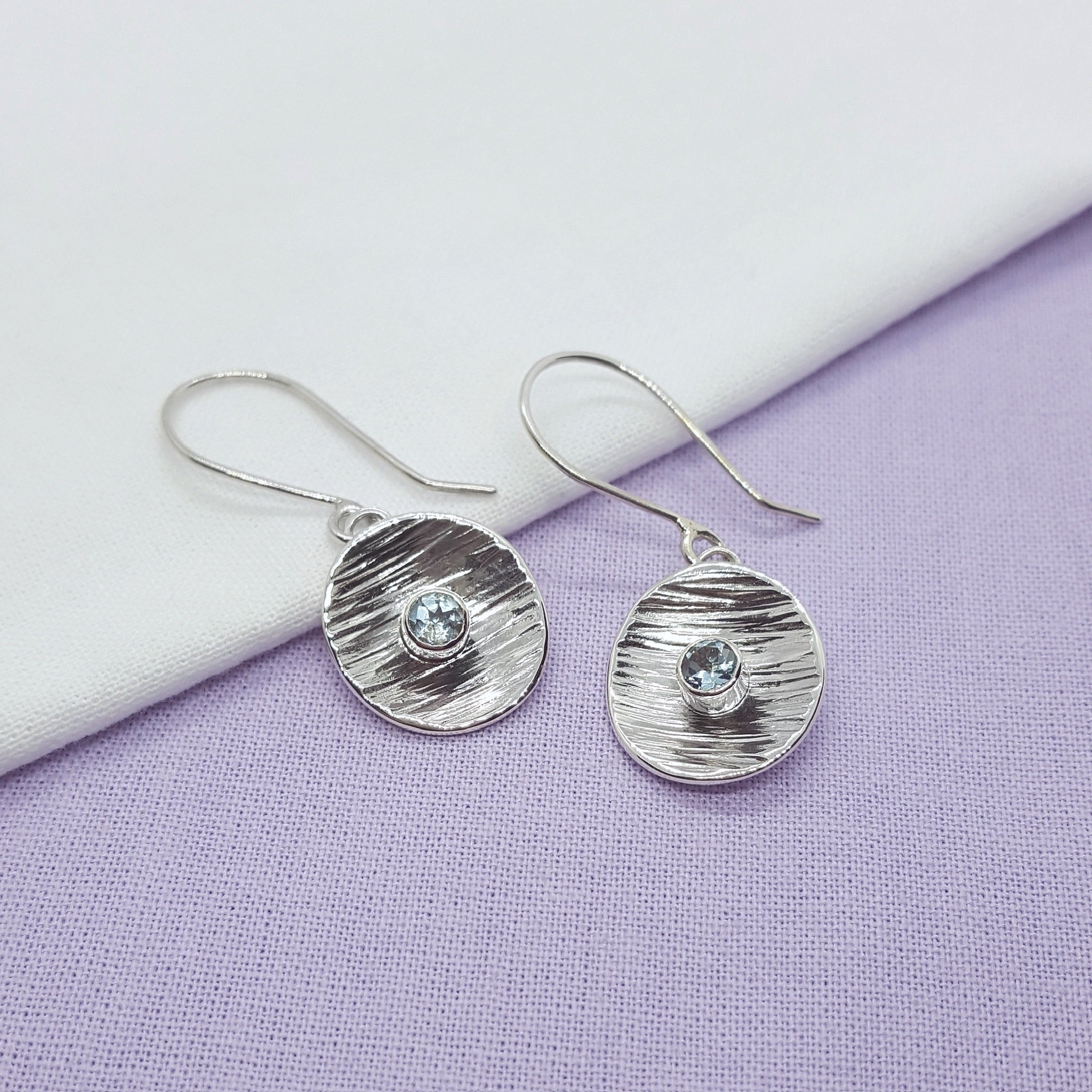 light blue swiss topaz and textured silver dangly earrings, handmade in kent