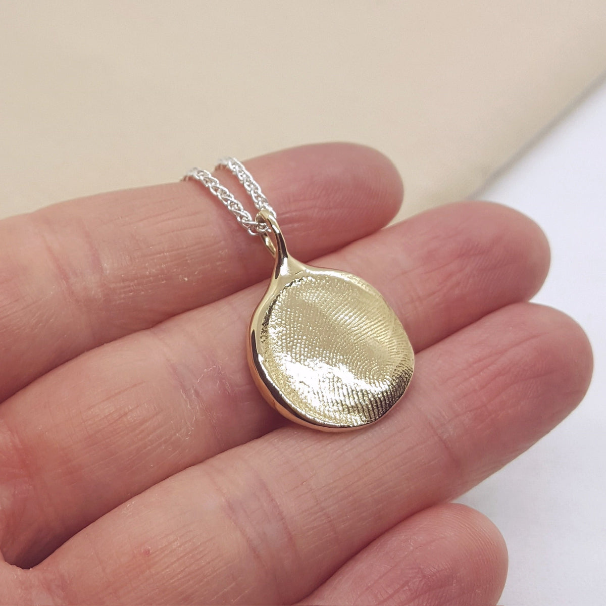 9ct yellow gold fingerprint pendant on a silver spiga chain
