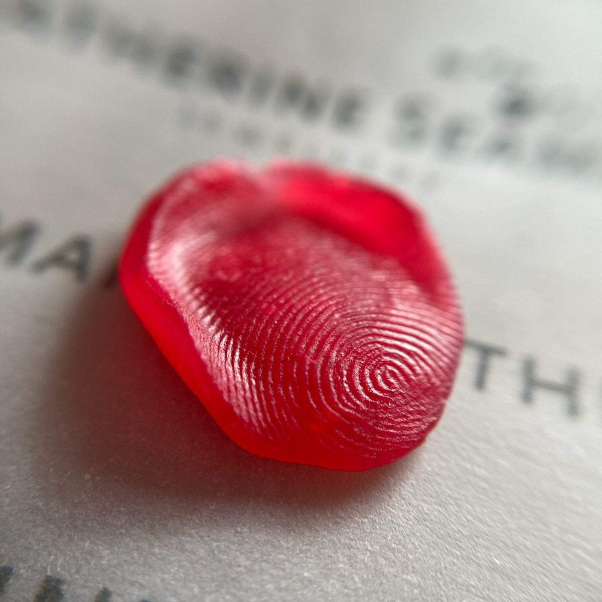 Red fingerprint on a piece of paper with text