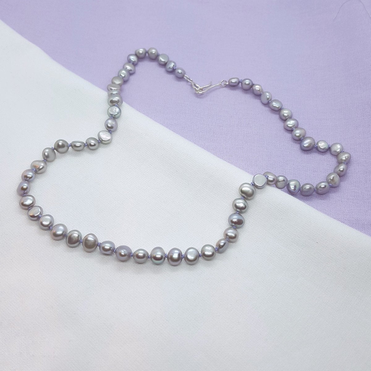 grey freshwater pearl necklace hand knotted on lilac silk thread and finished with a handmade silver clasp