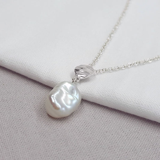 white keshi pearl necklace with silver texture detail, hanging on a silver trace chain, handmade jewellery in Kent