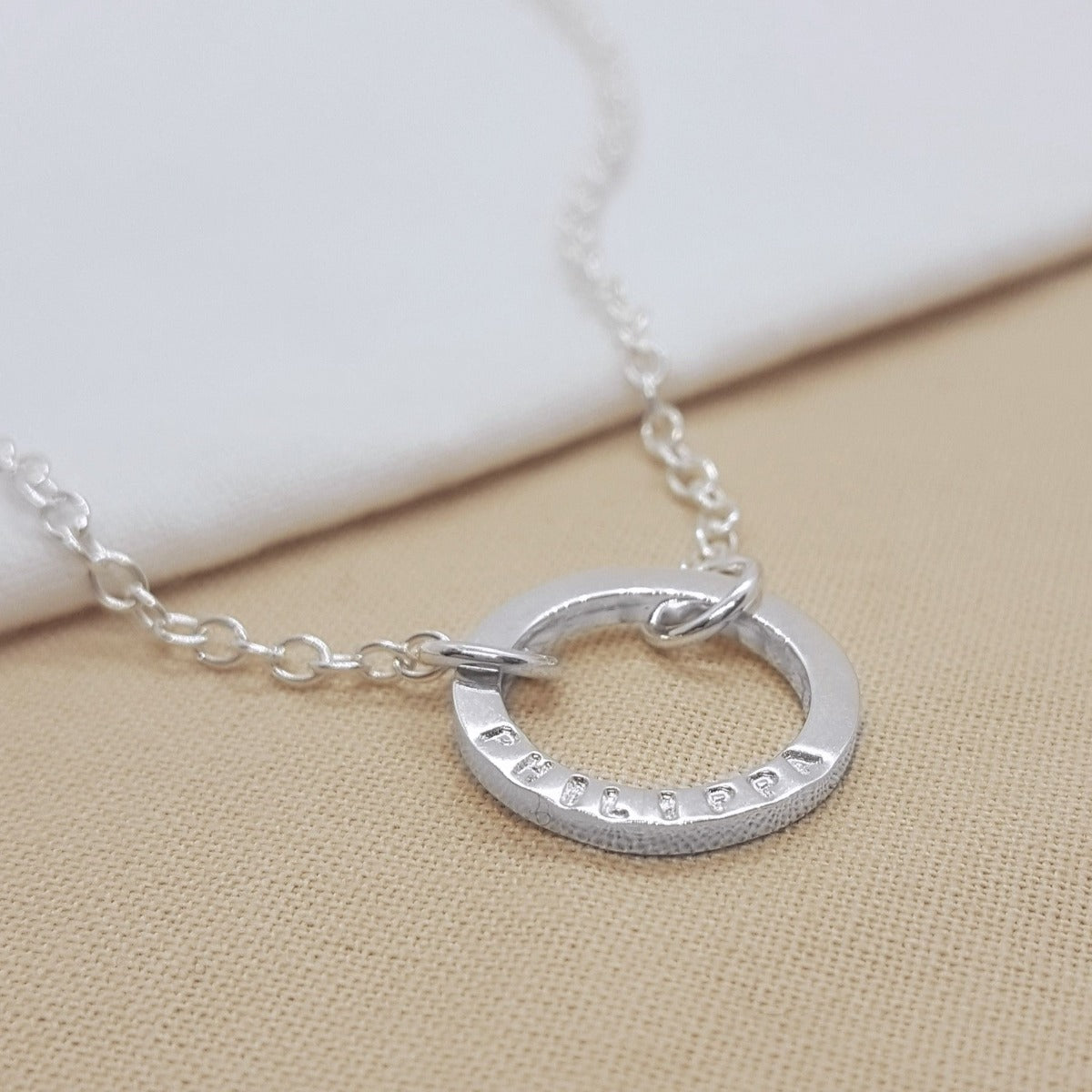 Silver circle necklace handmade with a name, date or message. Handmade in Kent