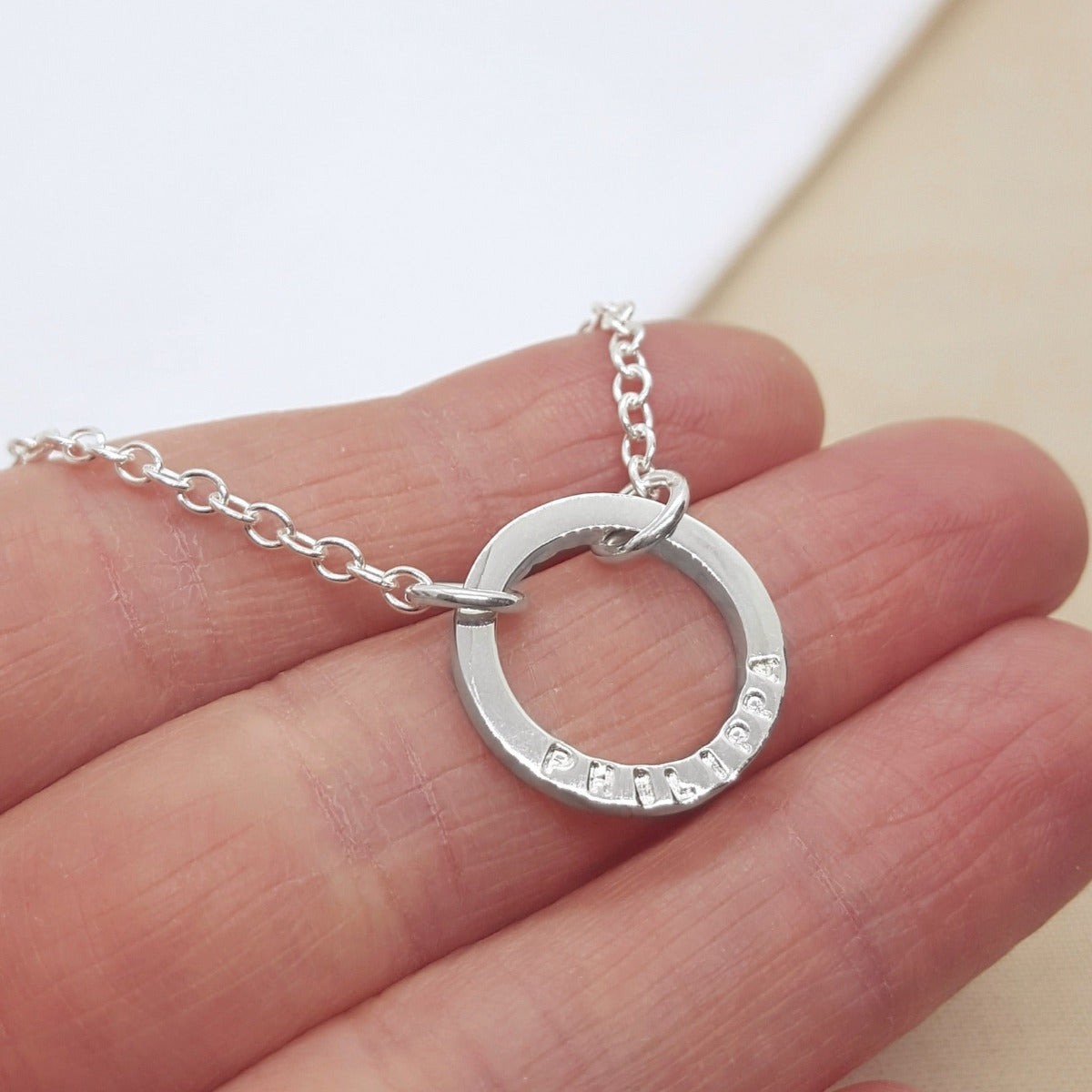 Silver circle necklace handmade with a name, date or message. Handmade in Kent