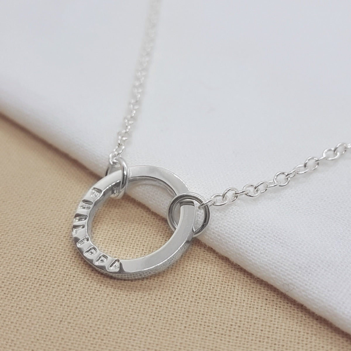 Silver circle necklace handmade with a name, date or message. Handmade in Kent