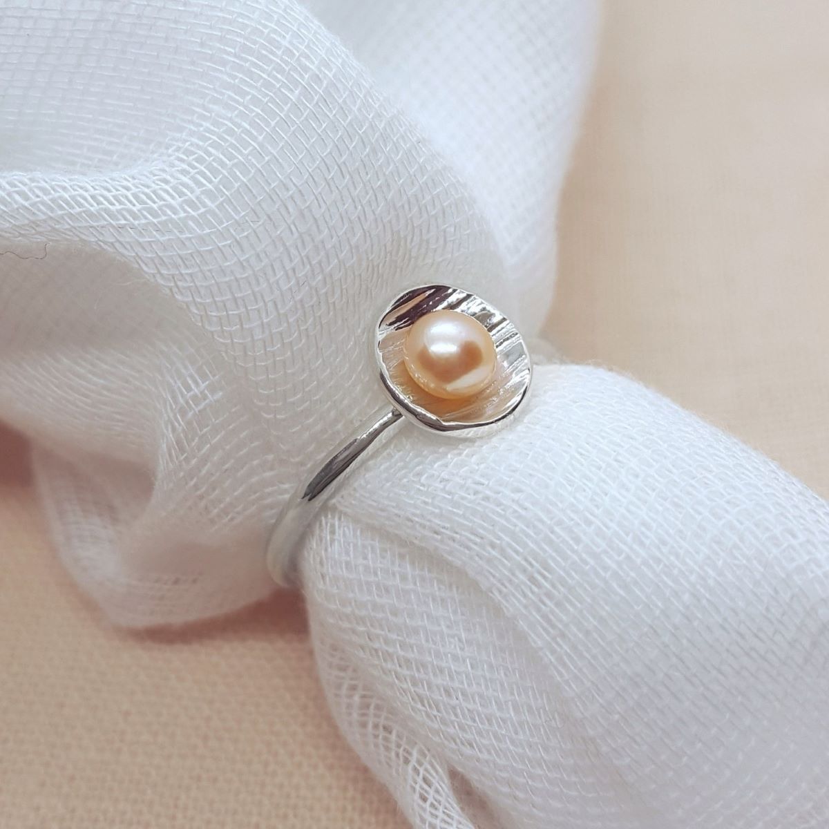 Peach freshwater pearl set in a textured silver cup ring, jewellery handmade in Kent