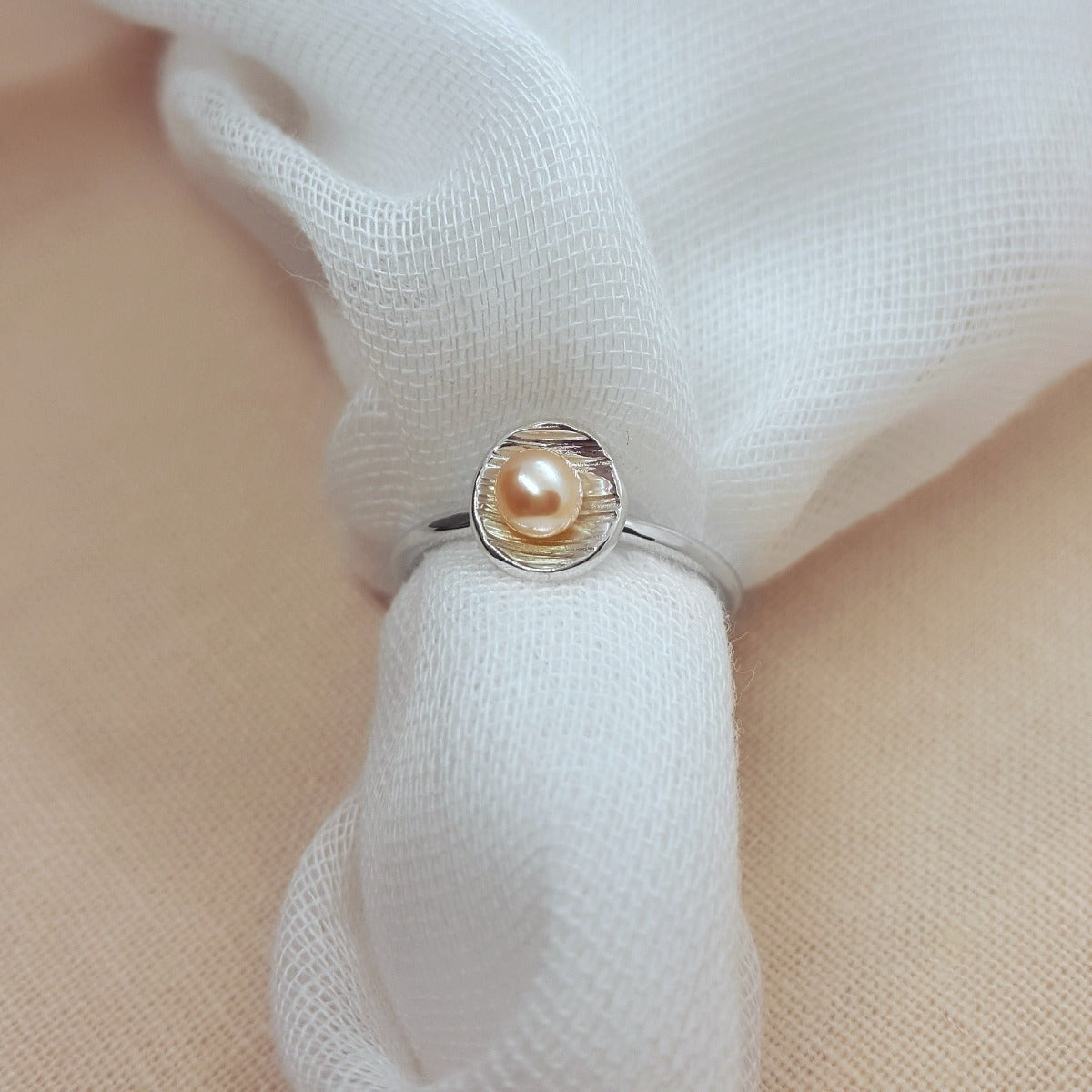 Peach freshwater pearl set in a textured silver cup ring, jewellery handmade in Kent