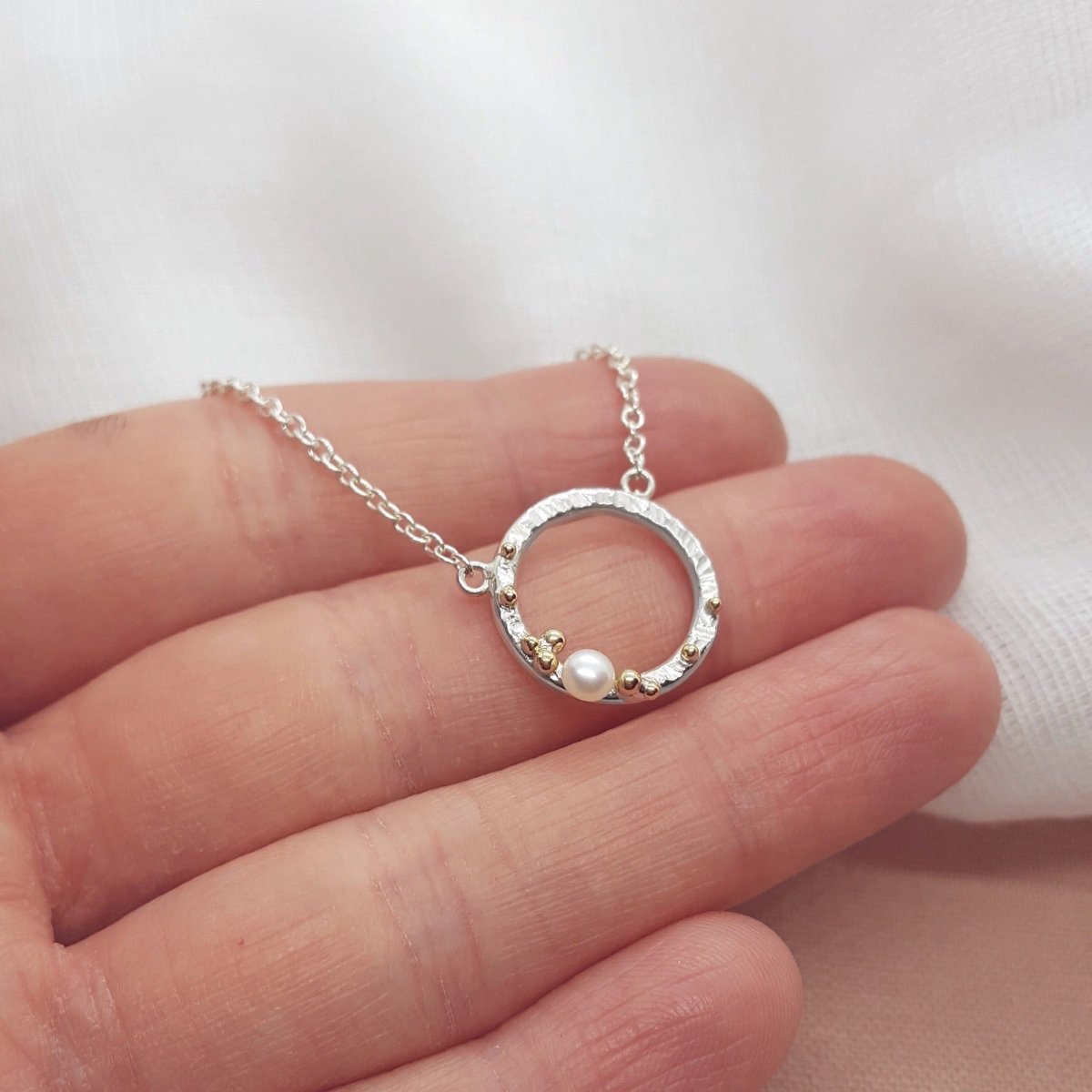 silver and 9ct yellow gold circle necklace set with a white pearl.