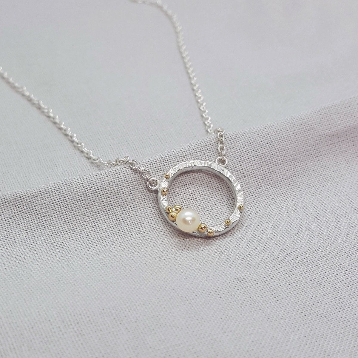 silver and 9ct yellow gold circle necklace set with a white pearl.