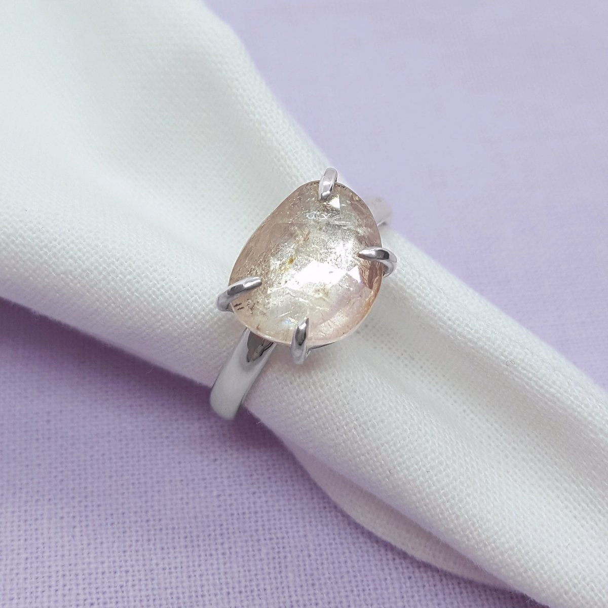 large rose cut clear tourmaline with flashes of pale pink, set in a handmade silver ring.