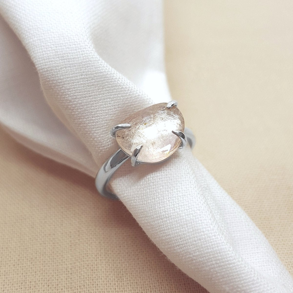 large rose cut clear tourmaline with flashes of pale pink, set in a handmade silver ring.