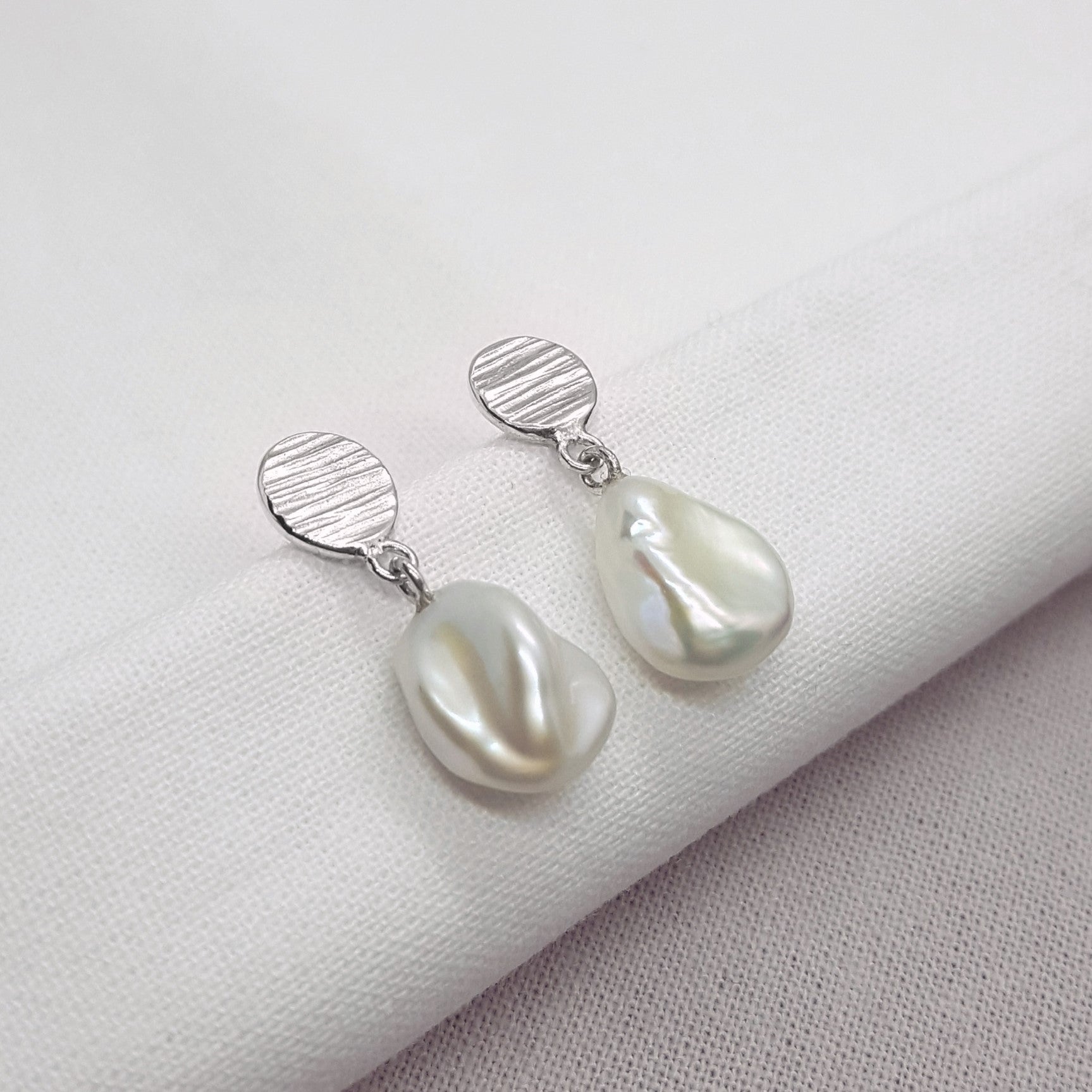 White keshi pearl drop earrings with textured silver details, handmade in Kent