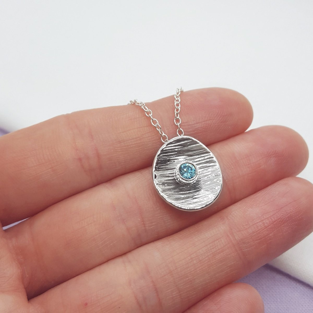 blue zircon set in a textured silver disc. handmade in the Kent countryside