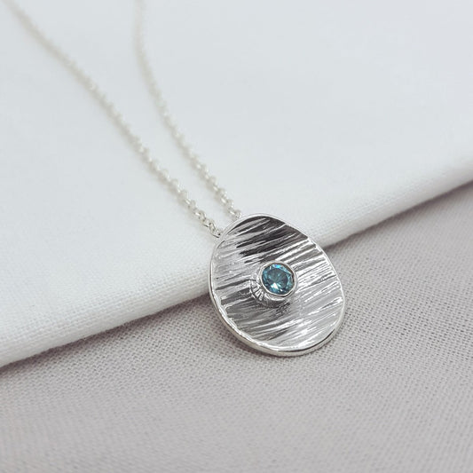 blue zircon set in a textured silver disc. handmade in the Kent countryside