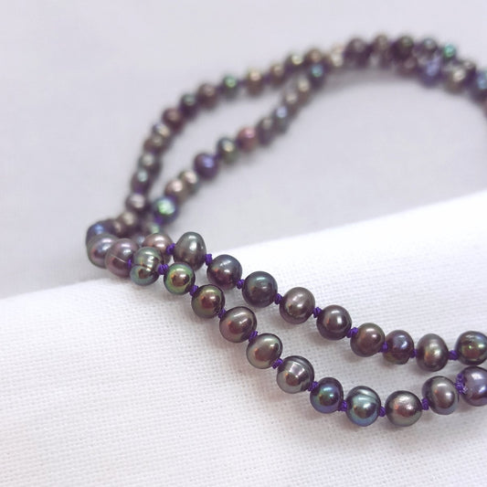 peacock coloured freshwater pearl necklace hand knotted on purple silk thread with a handmade silver clasp