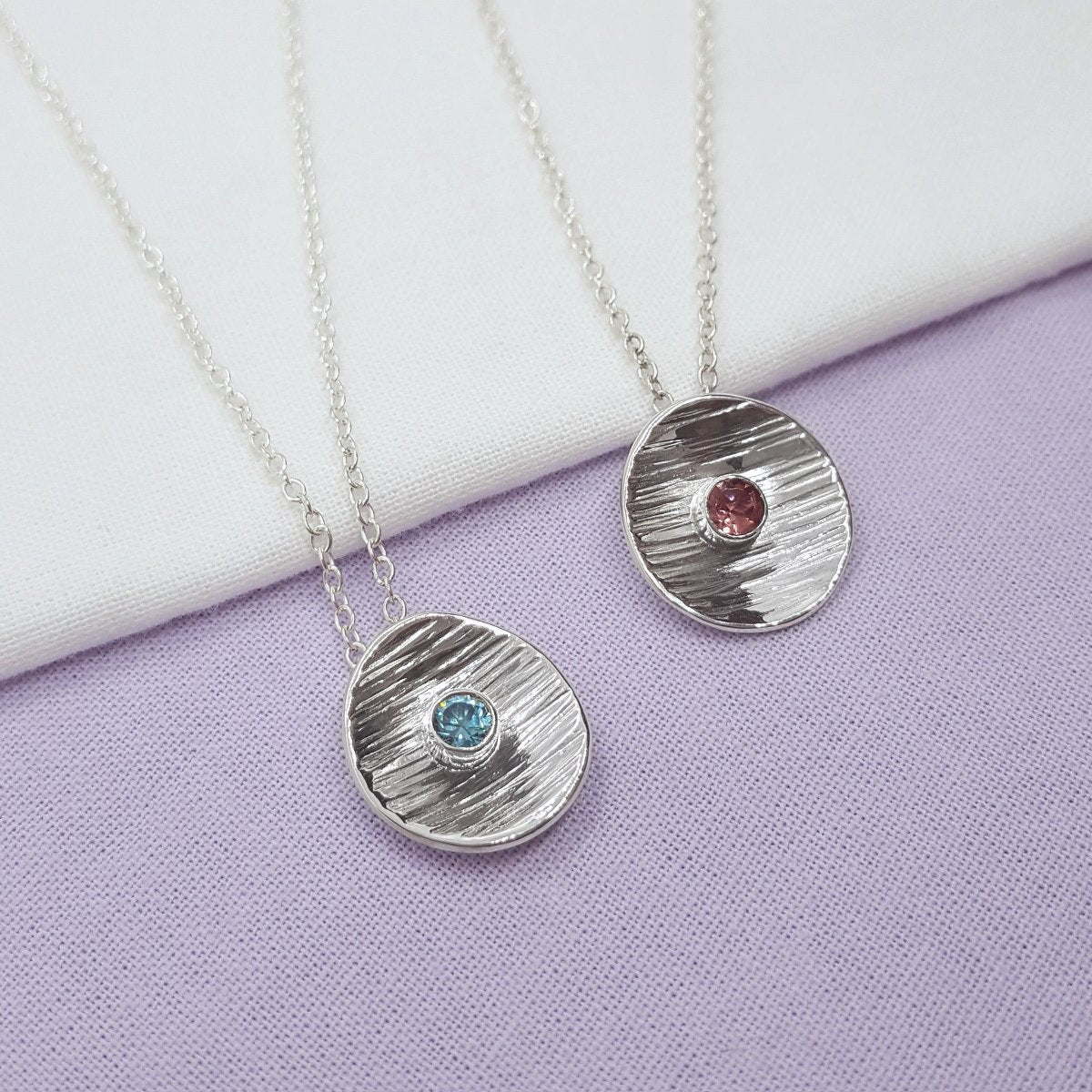 faceted round pink tourmaline tube set in a silver textured disc. Hanging from a trace chain. Handmade in the Kent countryside. 