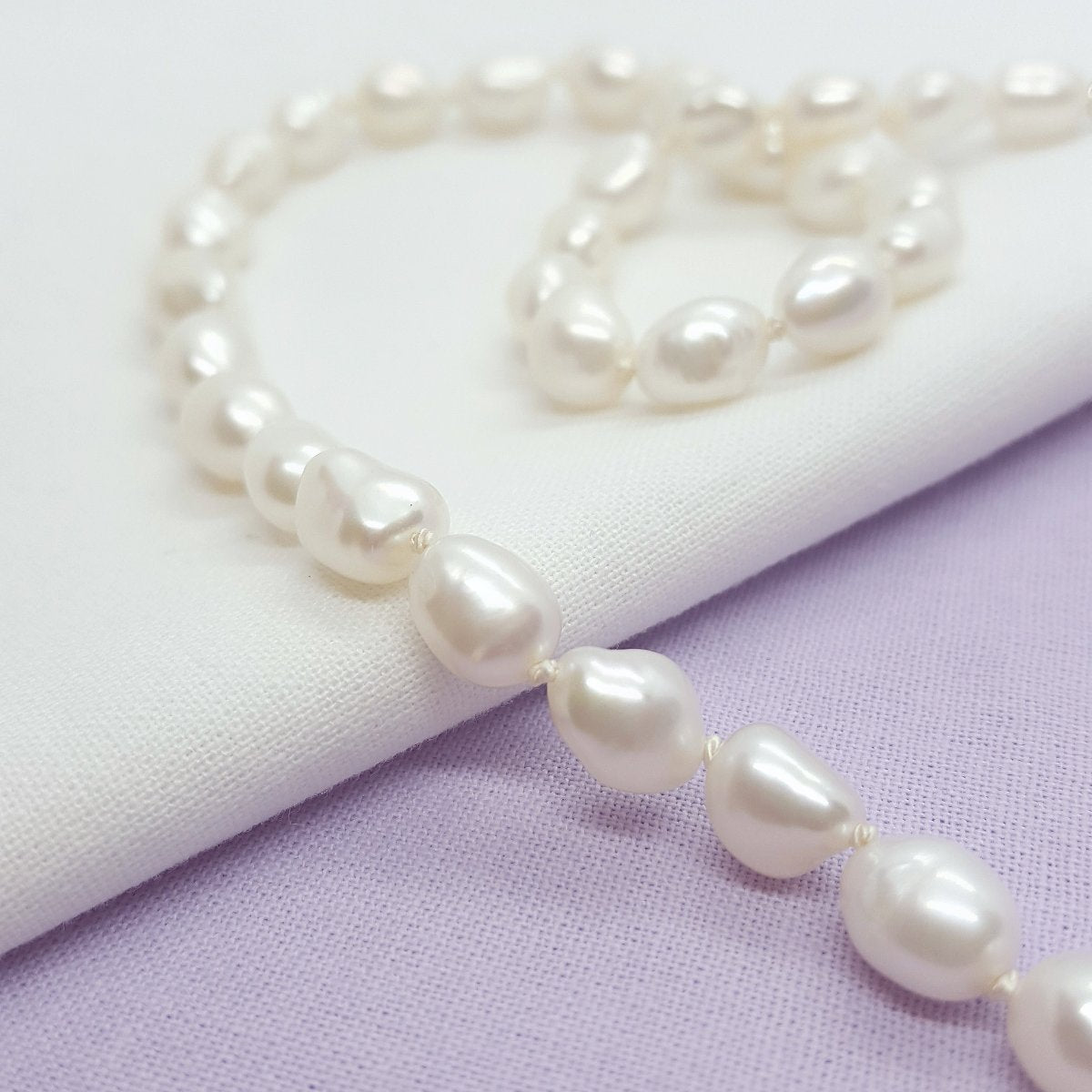 white baroque freshwater pearls hand knotted on white silk thread and handmade silver clasp