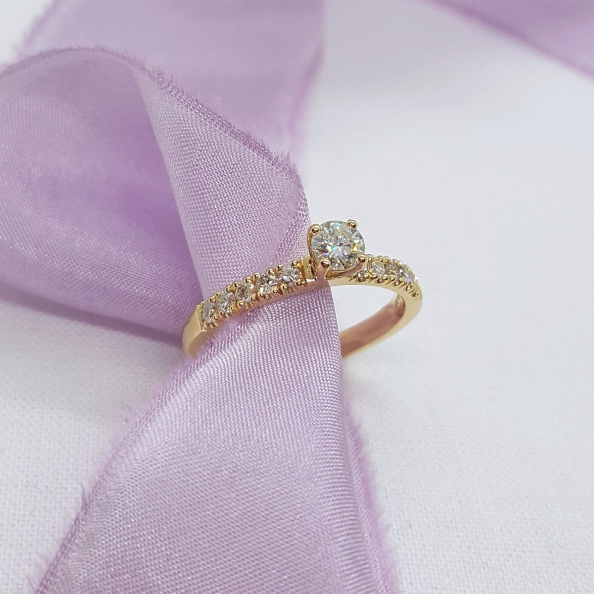 Gold ring with diamonds on a soft purple fabric